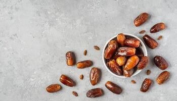 AI generated A top view of A bowl of juicy dates on a textured grey surface, capturing the essence of Ramadan. Ideal for iftar invitations or Ramadan greetings. Top view, Flat lay. photo