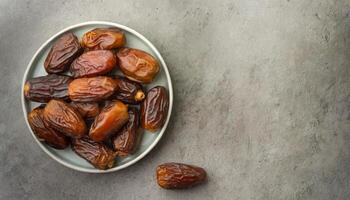 ai generado un cuenco de jugoso fechas en un texturizado gris superficie, capturar el esencia de Ramadán. ideal para iftar invitaciones o Ramadán saludos. parte superior vista, plano poner. foto