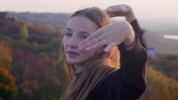 A girl dancing on a hill against the background of the sun video