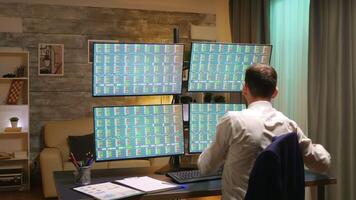 Back view of stock market broker in home office. Zoom in shot. video