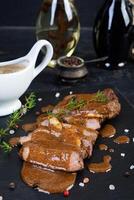 Grilled beef steak with herbs and spices on stone plate photo