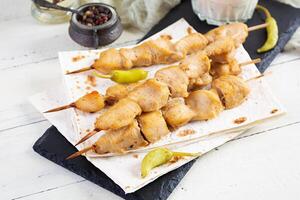 Chicken kebab with sour cream sauce. Chicken skewers on wooden background photo