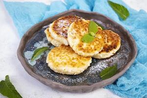 Sweet curd pancakes with mint. Cottage sheese pancakes or syrniki photo