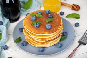 Delicious pancakes with blueberries and honey. Sweet pancakes with fresh berries photo