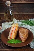 Sandwiches fried in breadcrumbs with ham, cheese and tomatoes photo