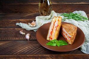 Sandwiches fried in breadcrumbs with ham, cheese and tomatoes photo