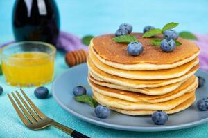 Delicious pancakes with blueberries and honey. Sweet pancakes with fresh berries photo