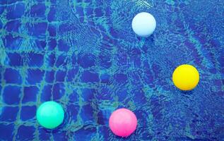 Top view of plastic balls floating on the surface of the water, bouncing up and down from the water waves, creating beautiful blue and white patterns. photo