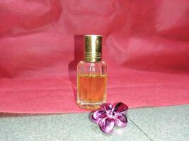 a small bottle of perfume sitting on a red cloth photo