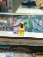 a small bottle of perfume sitting on a red cloth photo