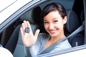 joven contento mujer conductor sostener coche llaves en su nuevo coche foto