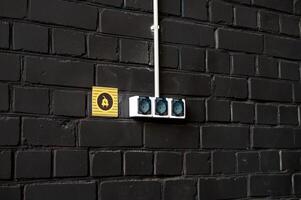 Electrical Outlets on Black Brick Wall photo