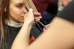 profesional peluquero tintura pelo de su cliente en salón. cortador de pelo cortando cabello. selectivo enfocar. foto