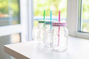 Three canning jars with colorful gingham lids, selective focus. photo