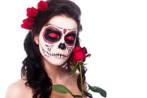 Day of the dead. Halloween. Young woman in day of the dead mask skull face art and rose. Isolated on white. closeup. photo