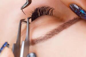 Eyelash Extension Procedure. Woman Eye with Long Eyelashes. Lashes, close up, macro, selective focus. photo