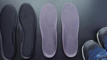 Orthopedic insoles and shoes on black background video
