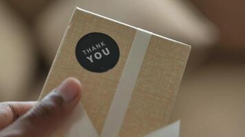 hand putting a thank you sticker on a gift box video