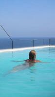 niña baños en el piscina con vista a el Oceano video