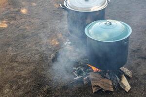 Cocinando en ollas en el campo con leña en mexico foto