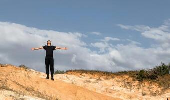 Happy man spreading his hands looking sky thanking on top of the mountain with space for text photo