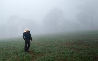 Cowboy man walking among foggy forest with space for text photo