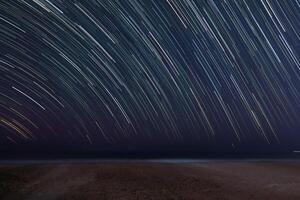 Star trail on beach background with space for text photo