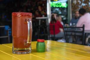 Michelada, Mexican drink of beer, clamato, salda, lemon and chamoy, with space for text photo