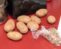 algunos rojizo patatas esperando a ser pelado y luego machacado para un familia cena foto