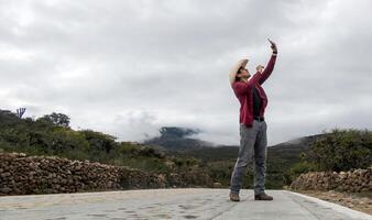 rancho hombre con su teléfono buscando para señal en rural área, con espacio para texto foto