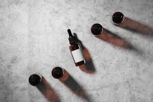 Dropper cosmetic five bottles mockup top the ground cement. abstract background for cosmetic presentation. 3D rendering photo