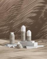 Examples of cosmetic bottles Placed on a white marble slab on a sandy background. vertical image. 3D rendering photo