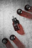 Dropper cosmetic five bottles mockup top the ground cement. abstract background for cosmetic presentation. 3D rendering photo