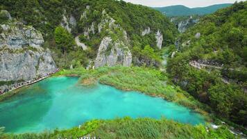 Hiking trail over mountain lake. Path for tourists in national park with waterfalls. Plitvice Lakes National Park Croatia. video
