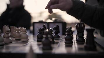 Playing chess in the park at sunset. Pieces on a chessboard. video