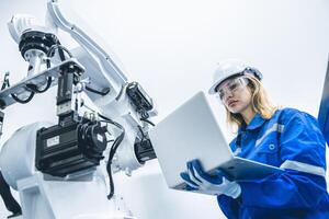 engineer woman worker working with robotic arm in productions lab research industry factory photo