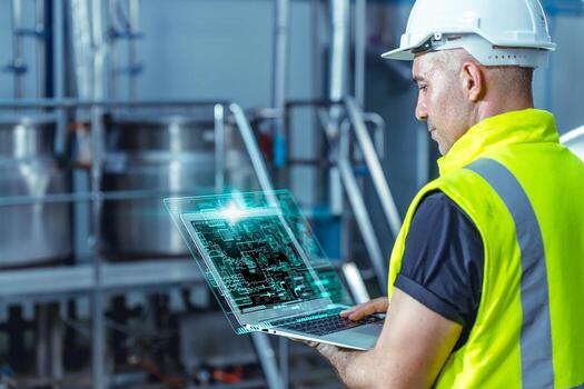 Smart engineer worker using software on laptop to monitor check factory boiler pipe valve control system photo