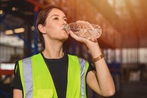 health care woman worker drinking clean water while working in hot place for refresh and personal healthy photo