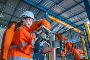 mujer inteligente ingeniero trabajador programación controlar robot montaje brazo en moderno metal industria fábrica foto