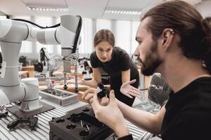 Industrial Robotics program university students learning education mechanical assembly with Robot Universal Training Platform robot arm simulation model in engineering lab classroom. photo