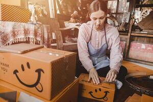 woman packing products order box send to customer freelance work for own business at home vintage tone photo