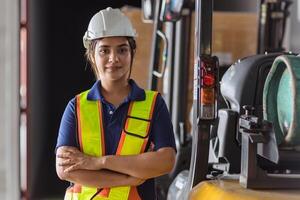 Indian woman staff worker engineer supervisor in safety suit work in factory warehouse photo