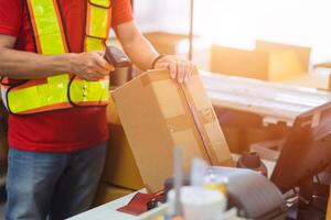 staff worker check postal label with laser barcode scanner at products box for shipping delivery to online order customer. photo