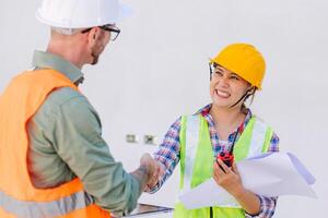 ingeniero constructor trabajador sacudir manos juntos contento sonriente para relación comercial proyectos co operación foto