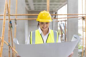 mujer constructor con piso plan mirando construcción Plano contento sonriente foto