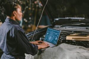 garage mechanic car engine engineer woman staff worker using laptop computer turning engine or check ECU combustion control photo