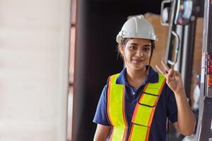 happy woman engineer worker Asian Latin Indian. lady staff in safety suit work in large factory warehouse cute action photo