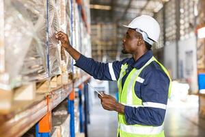 African black male warehouse worker focus working check shelf stock label in factory store photo