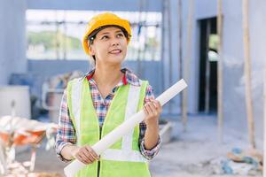 Engineer Architect builder Asian smart woman worker pride in work at construction site happy smiling. photo