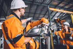 ingeniero equipo Servicio robot soldadura trabajando en automatización fábrica. personas trabajador en la seguridad traje trabajo robótico brazo software programación o reemplazando parte en automatizado fabricación industria tecnología. foto